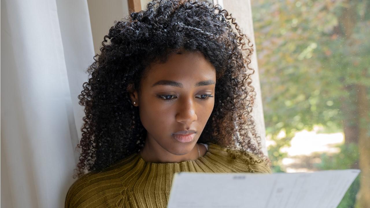 A woman looking at layoff paperwork