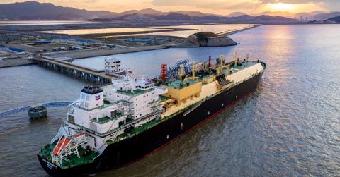 An oil tanker at a port at sunset