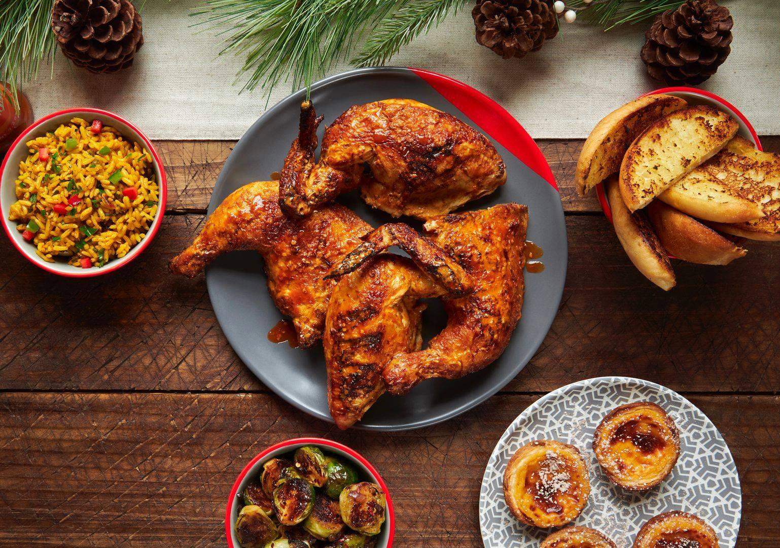 Image of roasted chicken on plate surrounded by sides