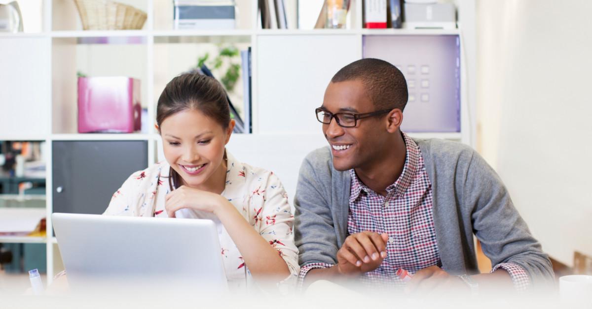 Smiling people looking at laptop