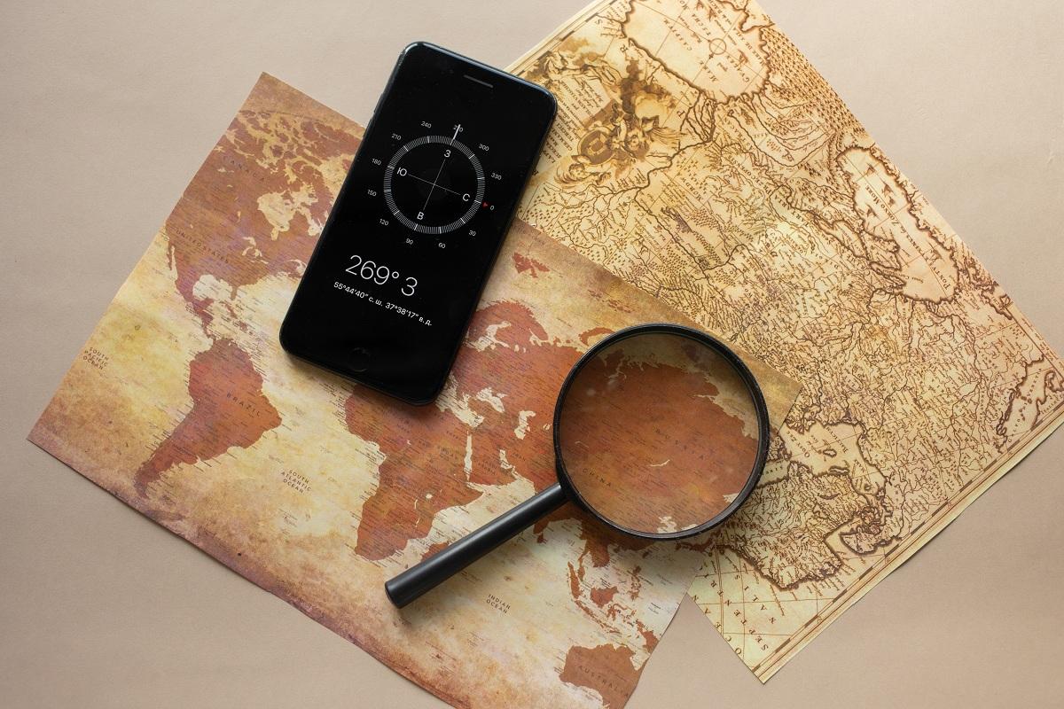 Magnifying glass and smartphone on a world map