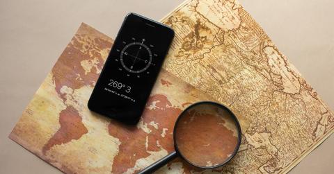 Magnifying glass and smartphone on a world map