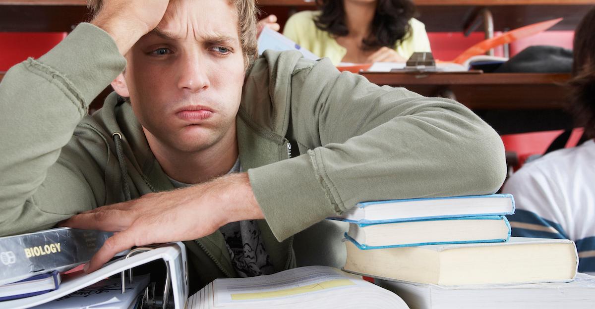 frustrated college student with sack of textbooks