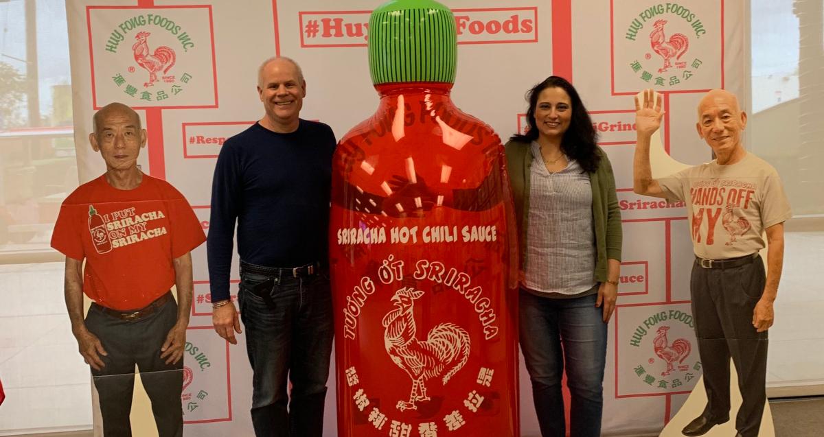 People posing by sriracha display