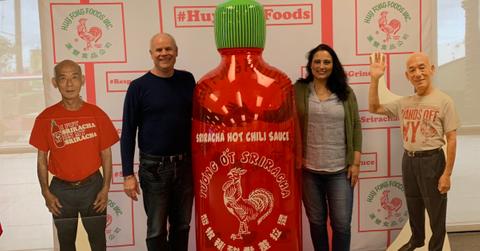 People posing by sriracha display