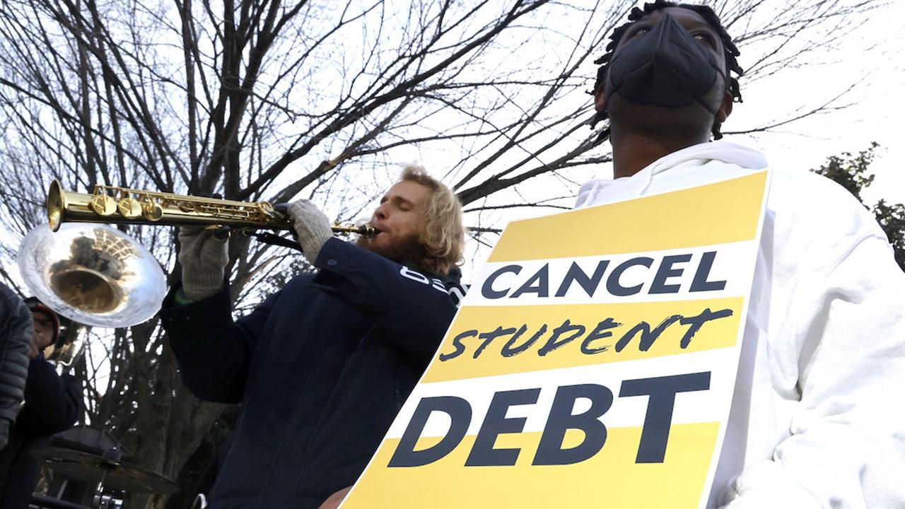 A student holding a sign about canceling student debt