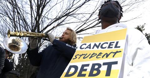 A student holding a sign about canceling student debt