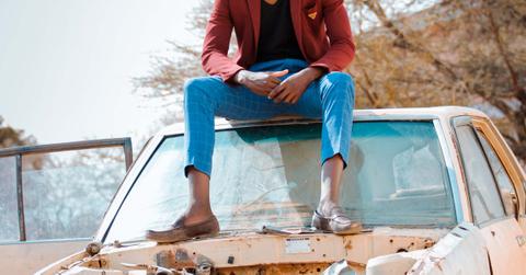A person sitting on top of a damaged car