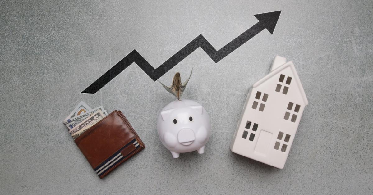 Cost of living concept: Piggy bank, wallet with dollar banknotes, and model of house.