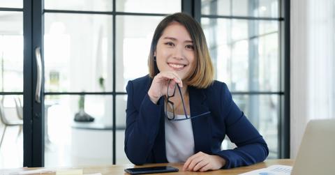 A female financial advisor wearing a navy blazer and sitting at a desk