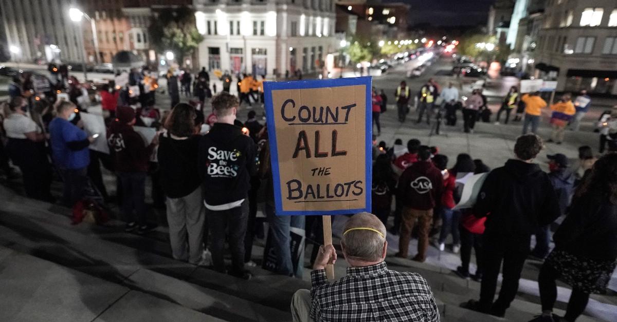 A man holds up a sign during a Count Every Vote demonstration at the Pennsylvania State Capitol.