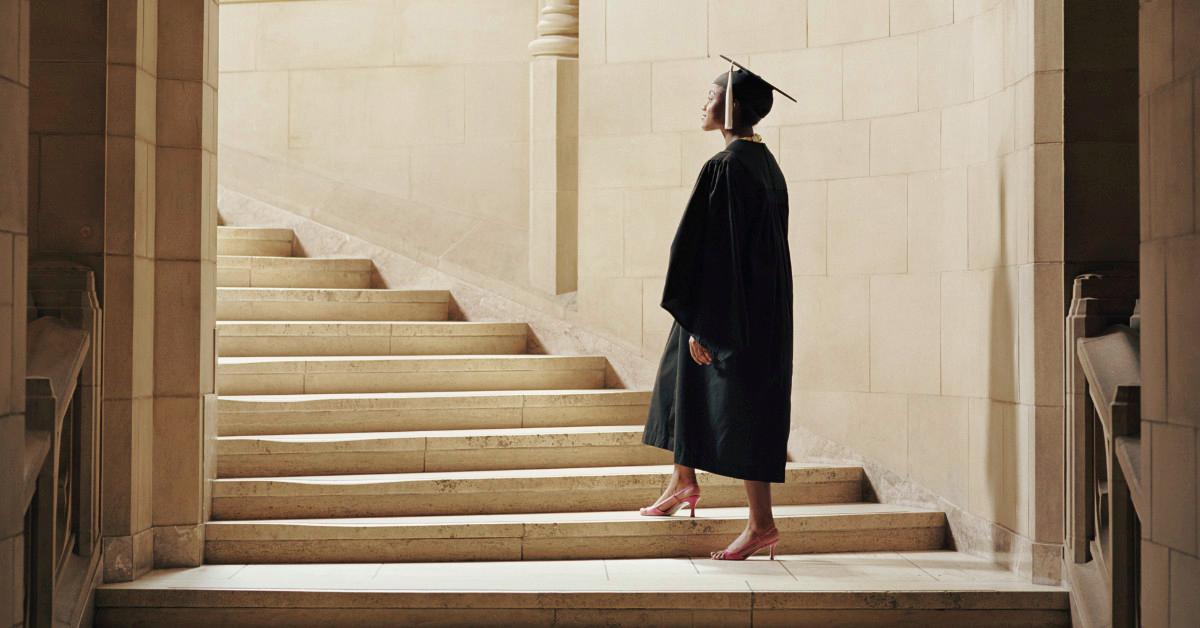 College graduate walking up steps