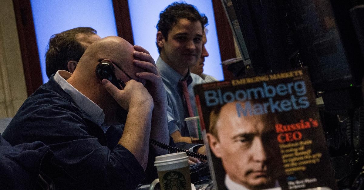 Stock market traders and a magazine with Putin on the cover