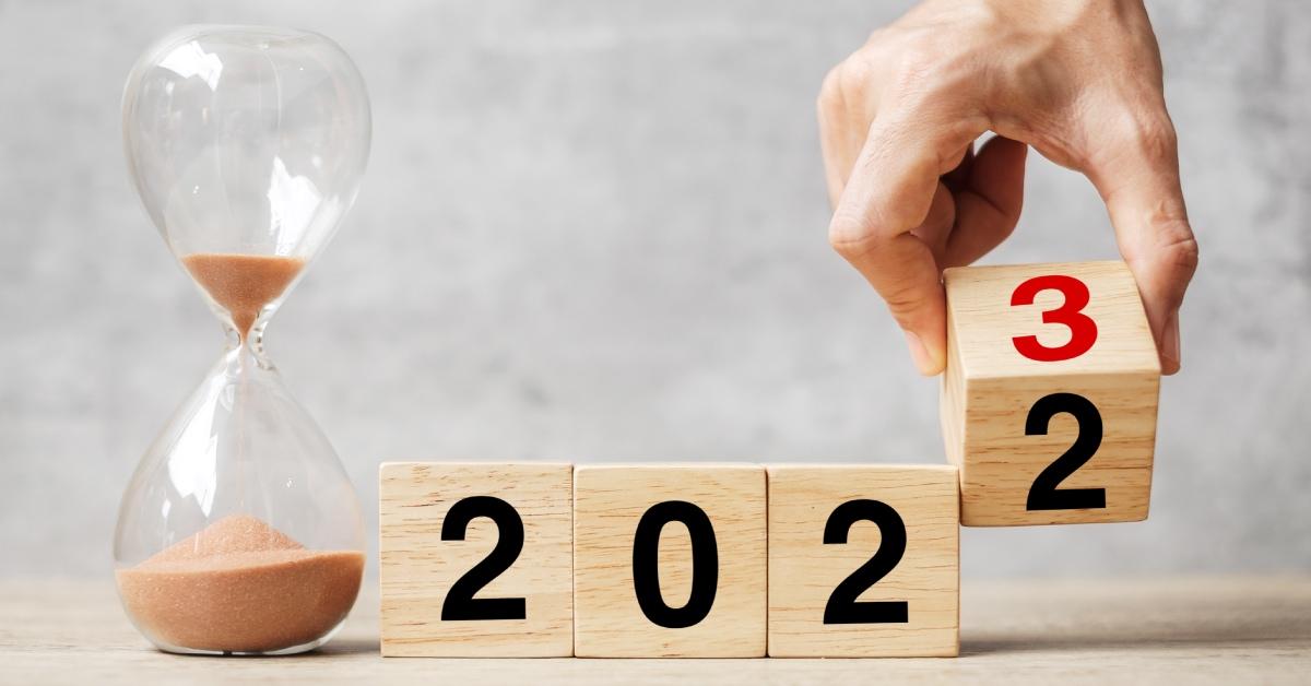 A hand flipping block 2022 to 2023 text with hourglass