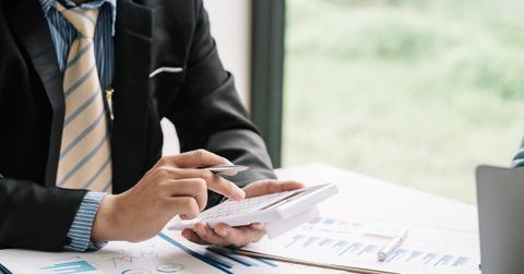 A businessman calculating tax lien investing amounts