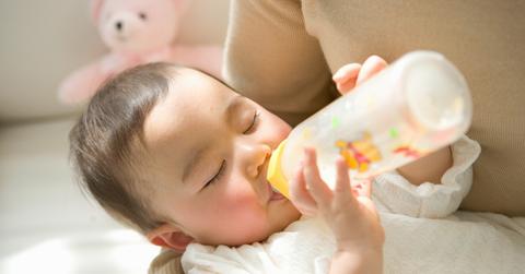 An infant nursing from a bottle