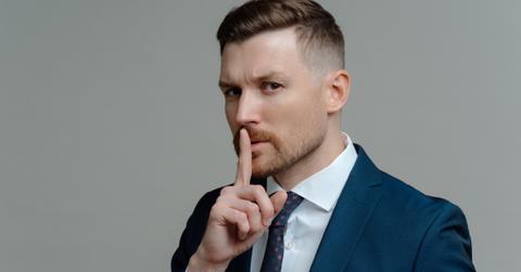 A person signaling to be quiet.