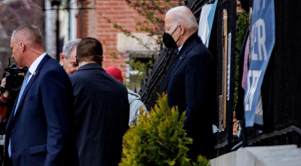 Joe Biden wearing a mask and exiting a building