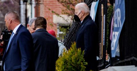 Joe Biden wearing a mask and exiting a building