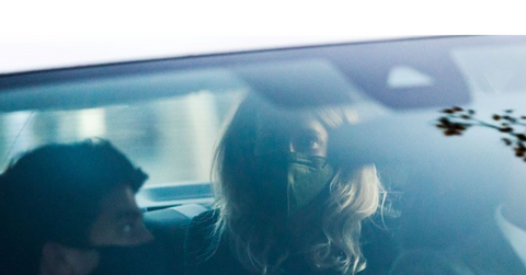 Elizabeth Holmes wearing mask seen through car windshield