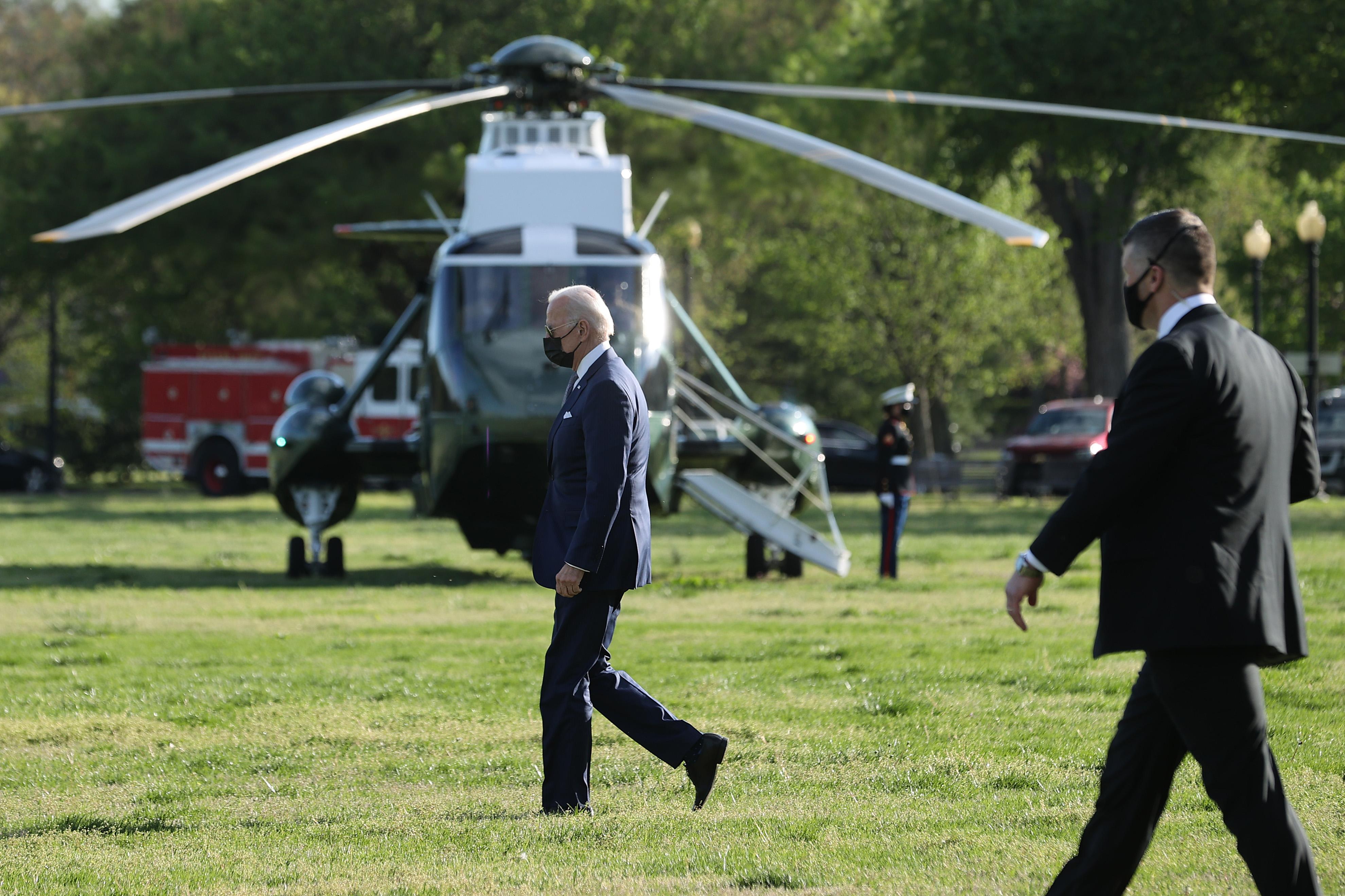 Joe Biden walking near private helicopter with secret service