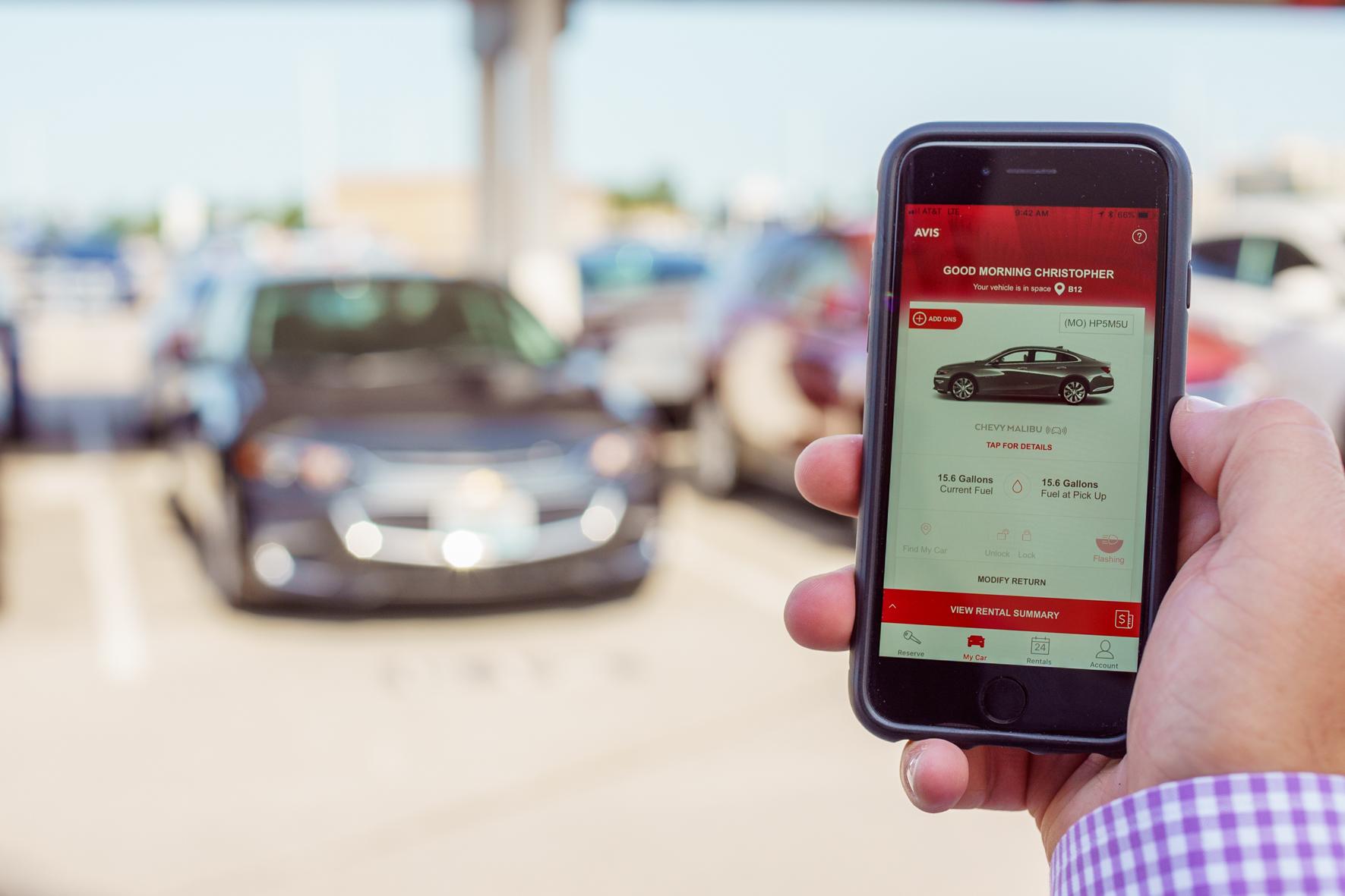 Avis app in front of car lot