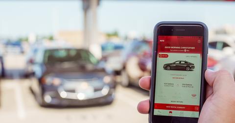 Avis app in front of car lot