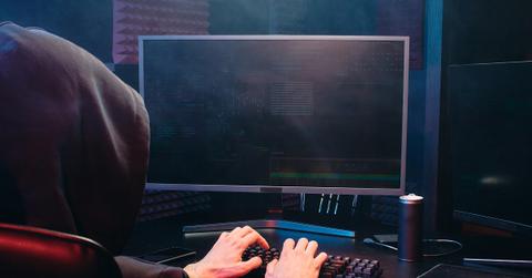 Person in a black hoodie using a computer