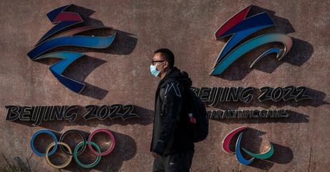 A visitor passs by China Olympics logo