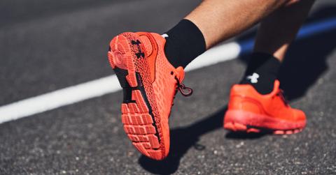 Person running in red-orange Under Armour shoes