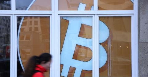 Woman walking in front of a Bitcoin sign