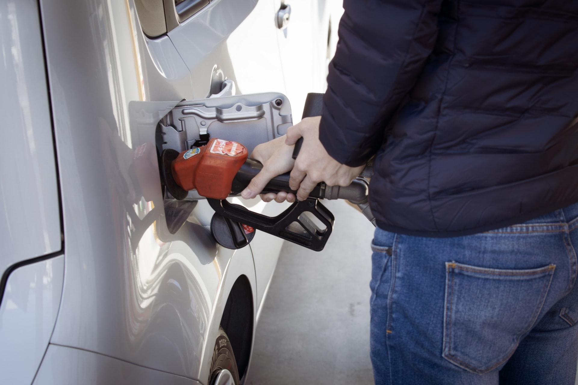 A person pumping gas at a gas station