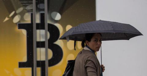 A person passes by a Bitcoin sign