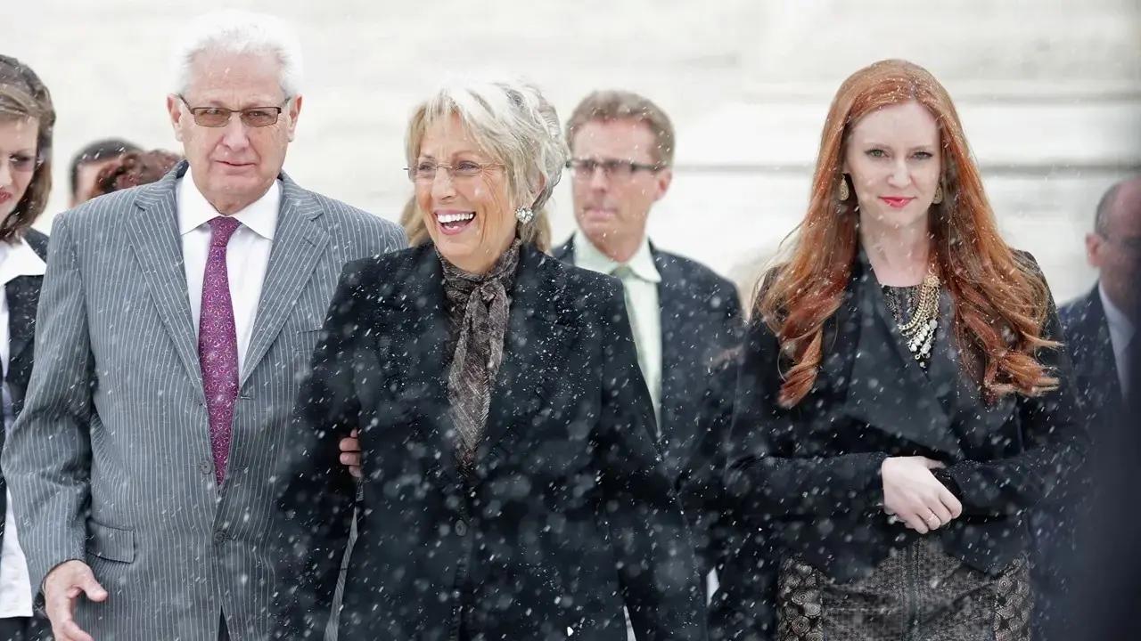 Hobby Lobby CEO David Green walking with his wife and others in snow.