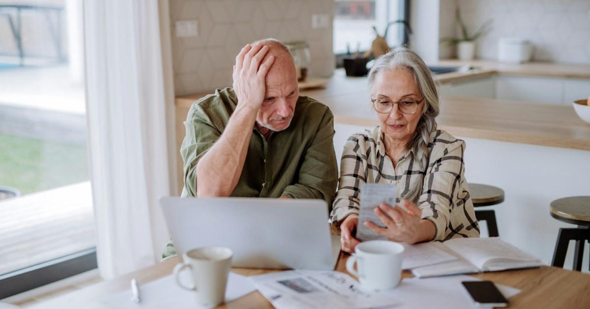 Elderly people people looking at documents confused.