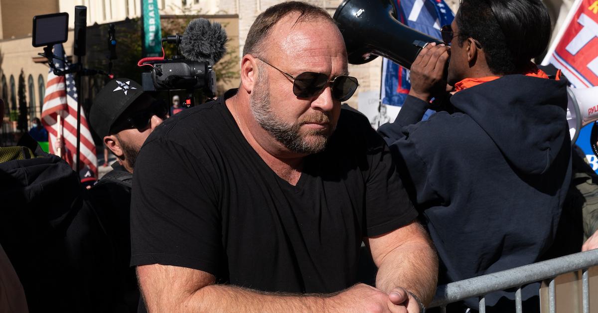 Alex Jones rests his arms on a security fence outside the Georgia State Capitol on November 18, 2020.