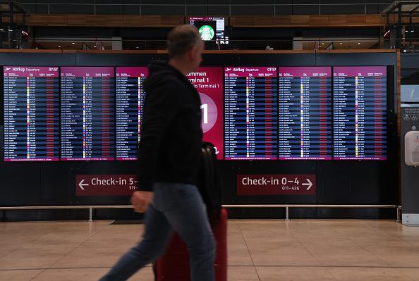 Man looking at flight board in an airport.