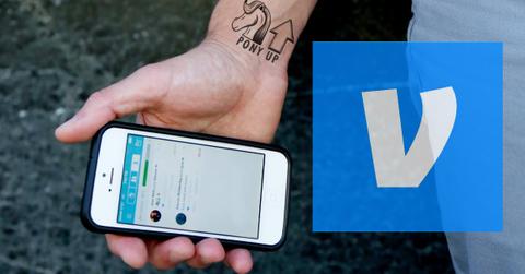 A person holding a smartphone displaying the Venmo app