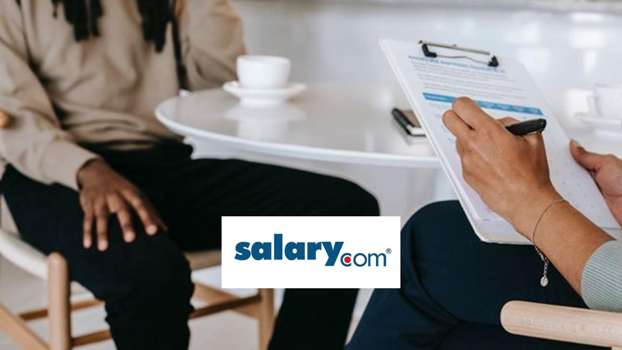 A person getting interviewed and the Salary.com logo