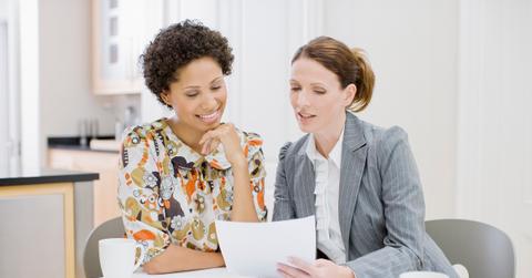 Businesswoman reviewing paperwork with woman