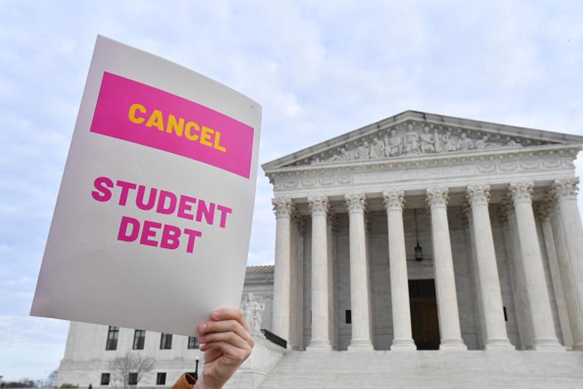 Protestor holding a cancel student debt sign in front of the Supreme Court