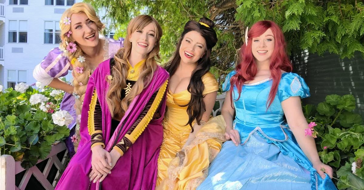 Four women dressed as Disney princesses at a party.