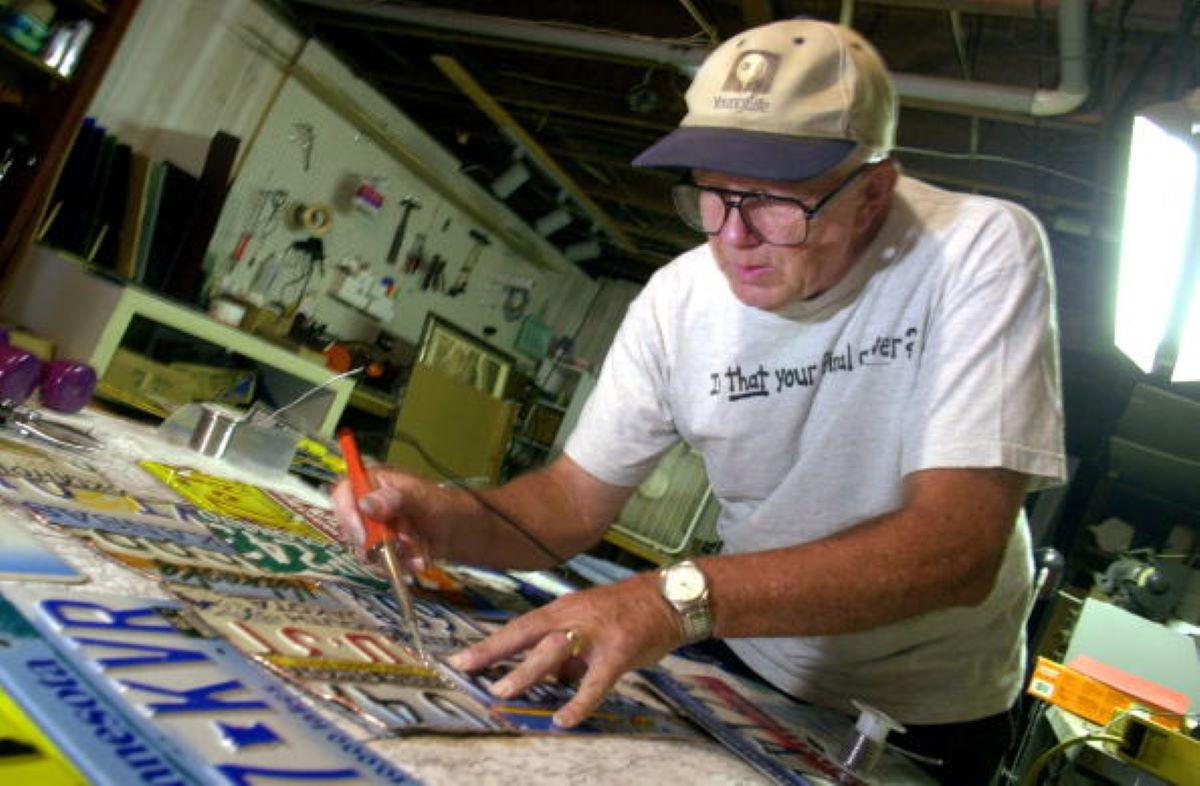 A man examining various license plates