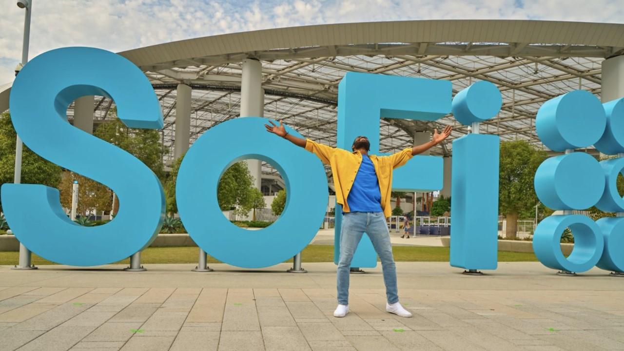 Man standing in front of a SoFi sign