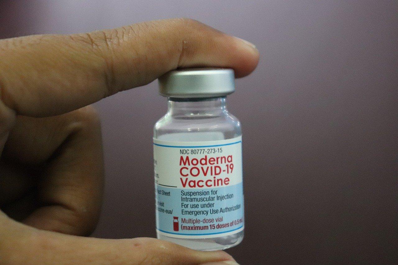 A hand holds a phial of Moderna's COVID-19 vaccine