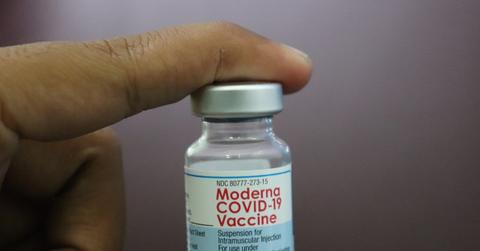 A hand holds a phial of Moderna's COVID-19 vaccine