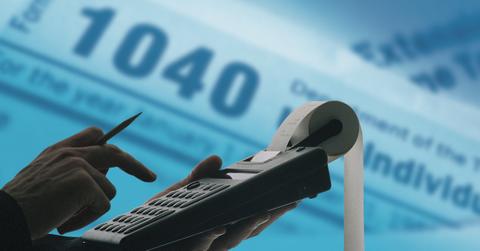 Person using a calculator for deferred self-employment tax