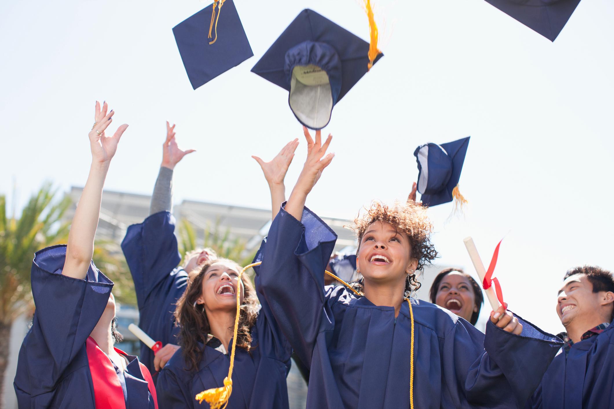 Students throwing mortarboards in the air