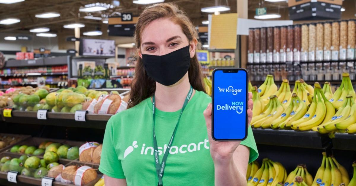 Instacart shopper holding a phone with the Instacart app on it