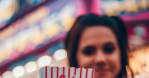 A woman holding a box of popcorn